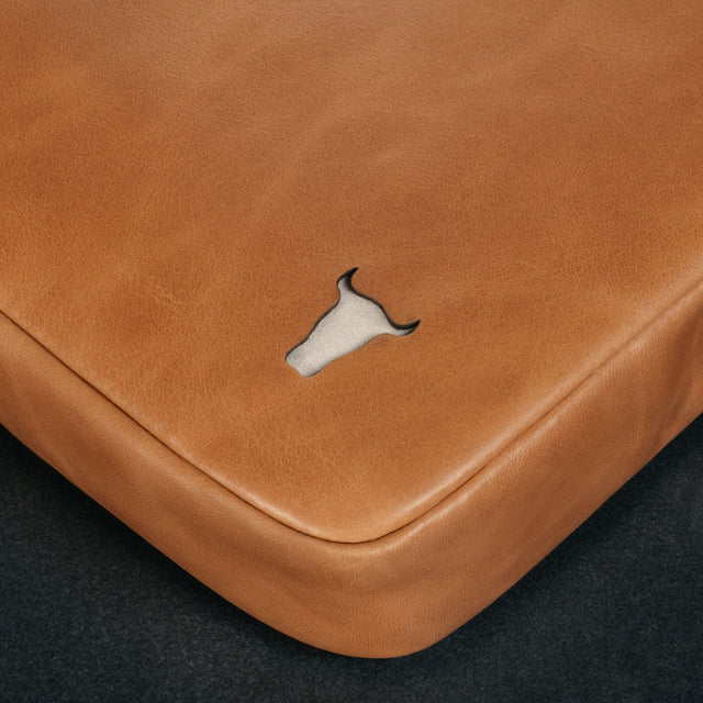 Tan Leather Messenger Bag on a wooden table