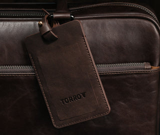 Dark Brown Leather Luggage Tag attached to luggage